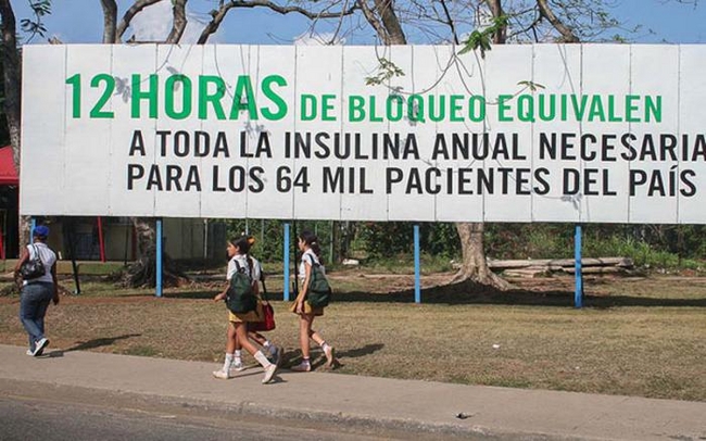 A billboard reads '12 hours of blockade are the equivalent to the annual insulin needed to treat the entire country's 64,000 patients'