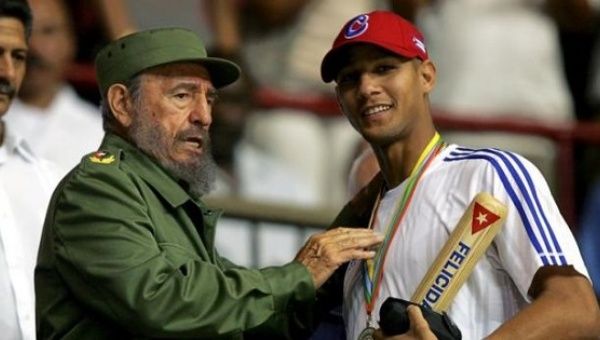 Late Cuban President Fidel Castro hands out a baseball bat to Cuban player Yulieski Gourriel in Havana. March 21, 2006.