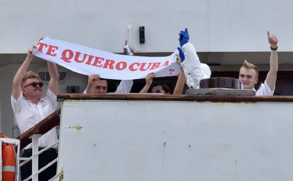 Crew members of British cruise ship MS Braemar hold a sign reading “I love you Cuba’’ at the harbor in Mariel, Cuba, on March 18, 2020. (Photo by Adalberto Roque/AFP via Getty Images