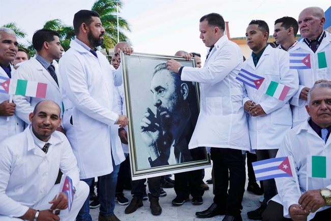 Cuban doctors hold an image of late Cuban President Fidel Castro during a farewell ceremony before departing to Italy to assist with the spread of the coronavirus outbreak, in Havana, Cuba, on March 2