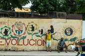 Two men standing near the wall with a mural Guille Álvarez (@guillealvarez)